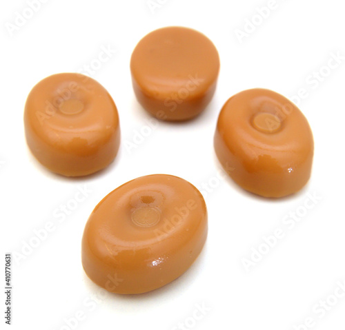 close up of caramel candies on white background