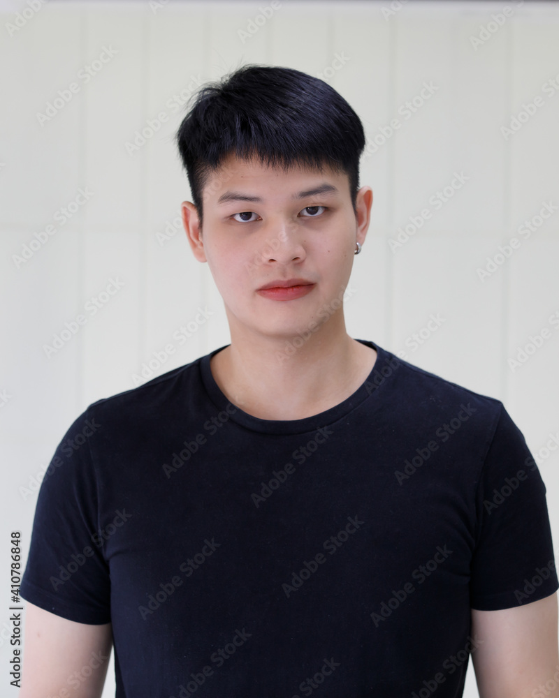 half body shot of young handsome and friendly Asian man wearing black t-shirt over white background. Concept of confident positive expression and happy people half body shot of young handsome and friendly Asian man wearing black t-shirt over white background. Concept of confident positive expression and happy people