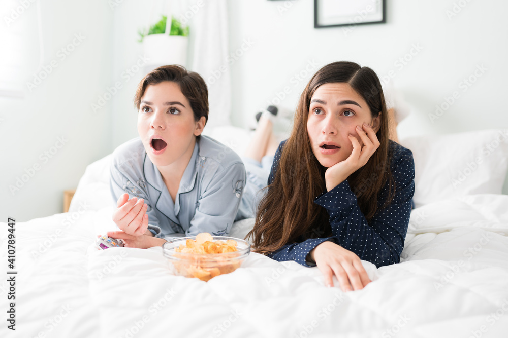 Best friends with their mouth open while watching movies in bed