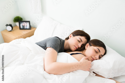 Young beautiful girlfriends asleep in a white comfy bed