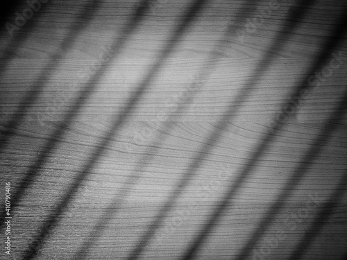 Black and white texture of wooden table background with blurred striped light.