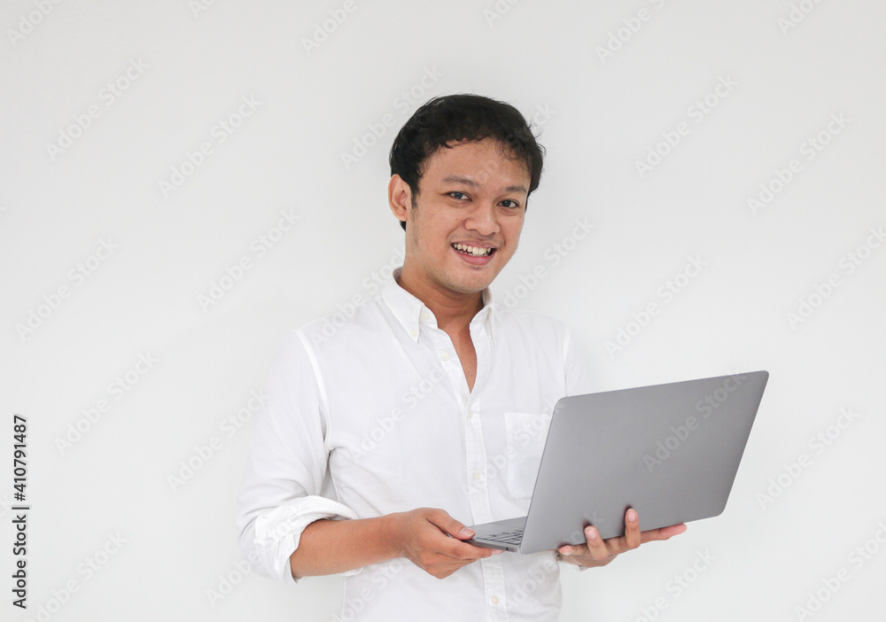 Young asian man is smile and enjoy when working at home with laptop computer. Work from home concept.