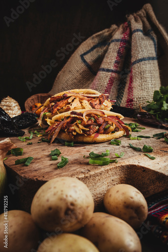 Bodegón de una deliciosa comida mexicana con chiles y vegetales al rededor en una tabla de madera