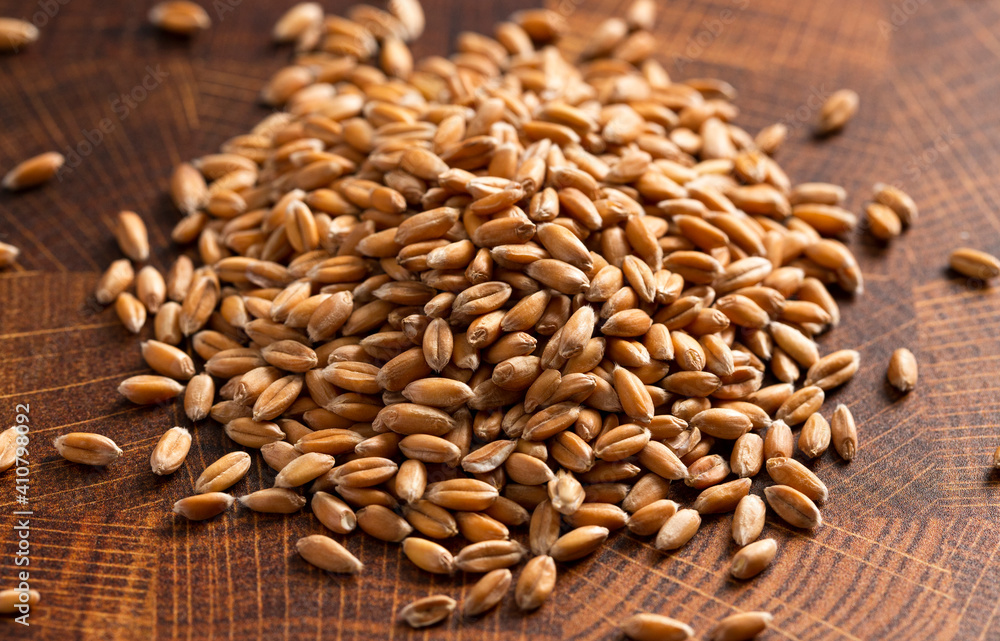 Pile of Spelt Grain on a Wooden Butchers Block Pile of Spelt Grain on a Wooden Butchers Block