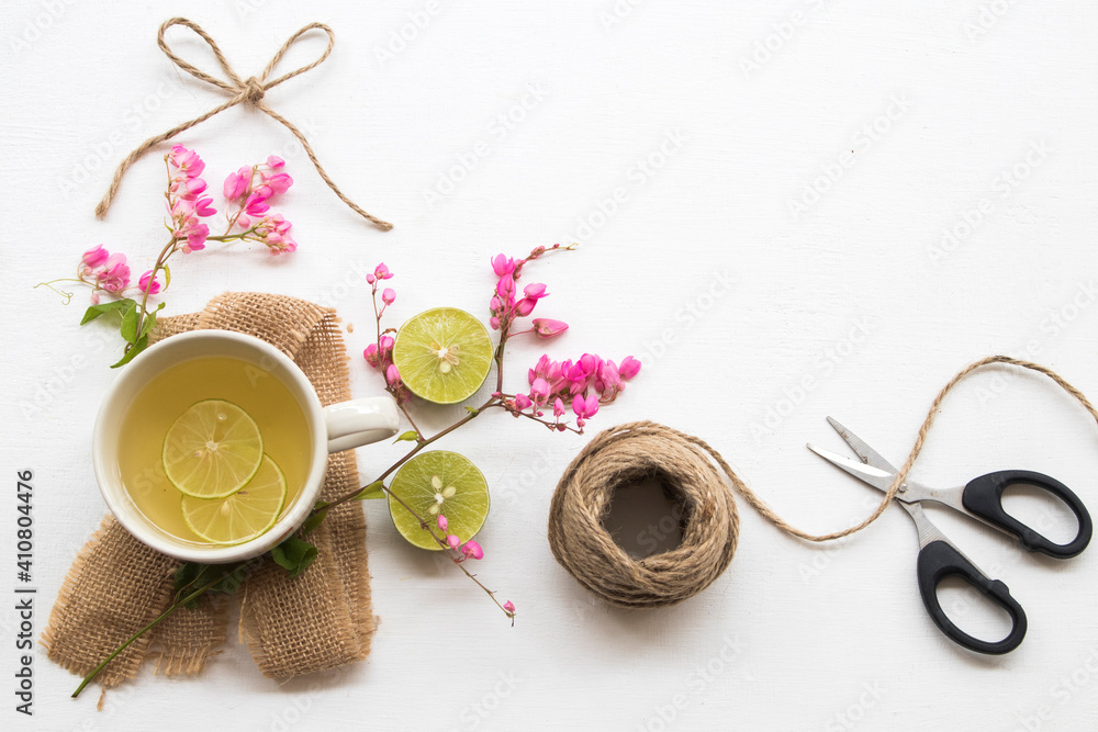 pink flower on sack with healthy drinks honey lemon for health care relax with scissors ,rope arrangement flat lay style on background white pink flower on sack with healthy drinks honey lemon for health care relax with scissors ,rope arrangement flat lay style on background white