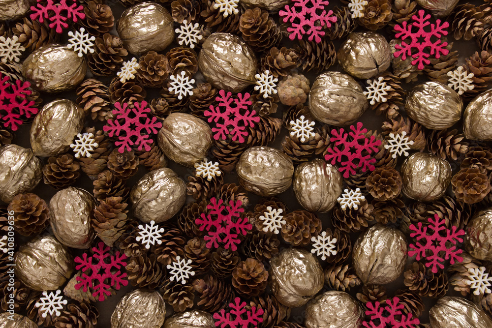 Festive Christmas background with many objects pinecones, golden walnuts, red and white snowflakes.