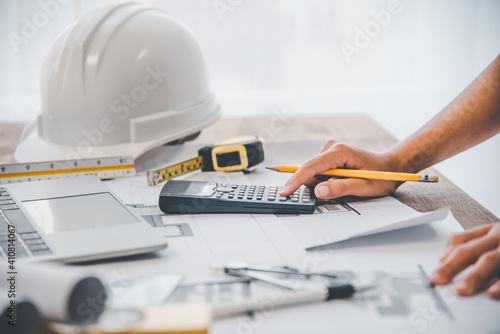 engineer use calculator working in office with blueprints, inspection in workplace for architectural plan, construction project, Business construction