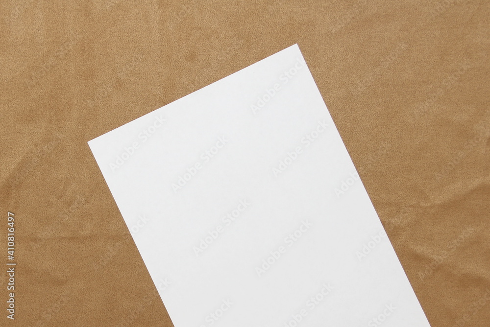 Template of white paper lies diagonally on light brown cloth background. Concept of business plan and strategy. Stock photo with empty space for text and design. Template of white paper lies diagonally on light brown cloth background. Concept of business plan and strategy. Stock photo with empty space for text and design.
