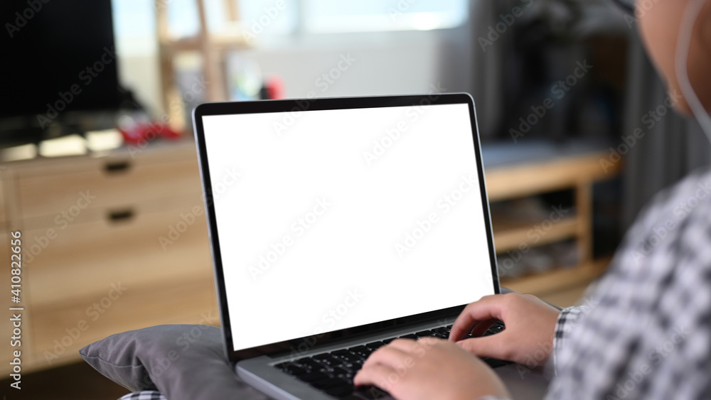 Close up view of young Asian girl sitting on comfortable sofa and using laptop computer. Close up view of young Asian girl sitting on comfortable sofa and using laptop computer.