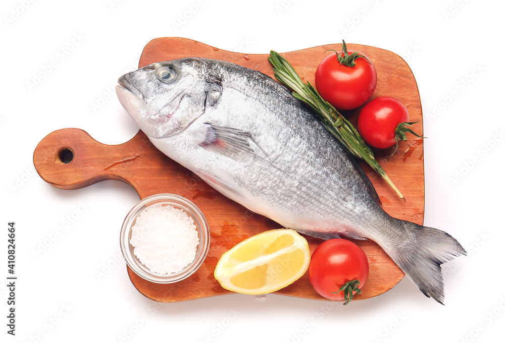 Board with raw dorado fish and ingredients on white background
