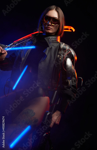 Fantasy portrait of a attractive female soldier with short haircut holding a futuristic sword on her shoulder and gun. Dangerous woman in cyberpunk style going in dark background.