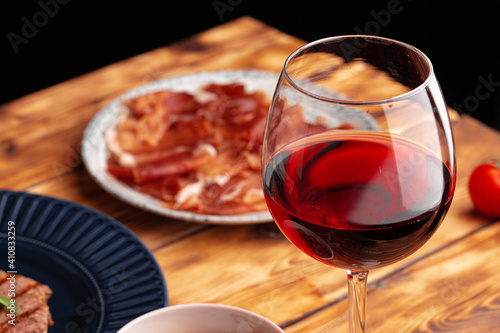Meat slicing and wine on gray background