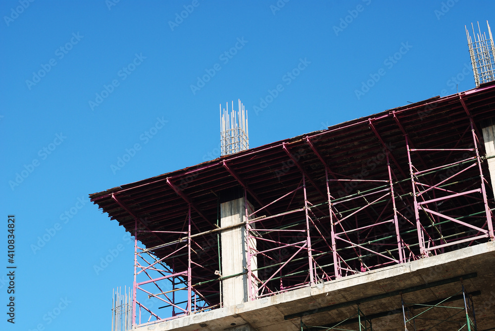 Close up image of construction site of an urban building complex. On going high rise building without people against blue sky background. Construction object background with copy space.