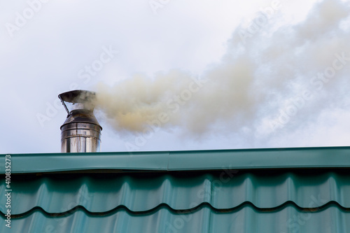 Smoke comes from the chimney. Stove heating. Pollution of the atmosphere by soot.