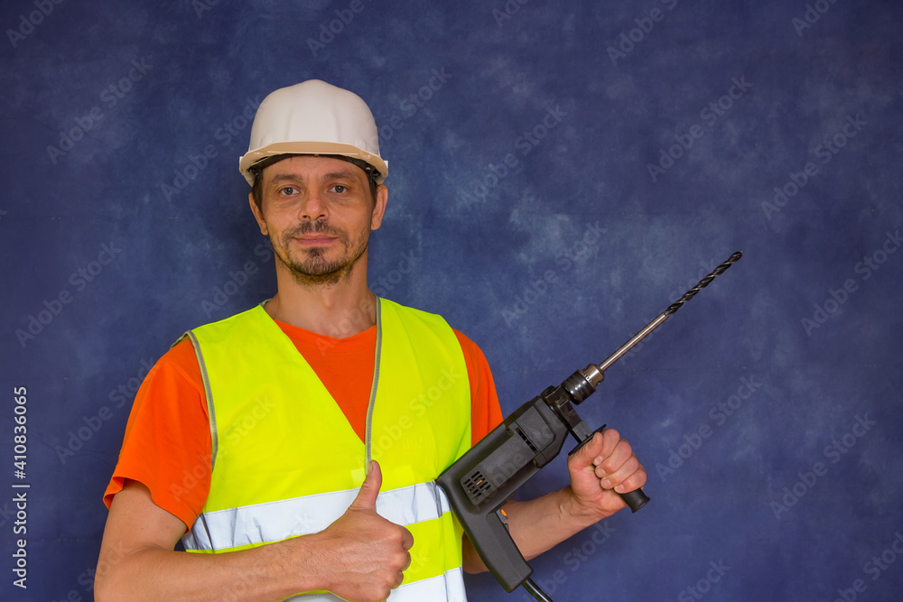 Male locksmith, builder. A worker with a tool in his hands and in working uniform. Male locksmith, builder. A worker with a tool in his hands and in working uniform.