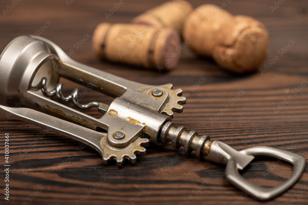 Corkscrew and corks from wine bottles on a wooden table. Corkscrew and corks from wine bottles on a wooden table.