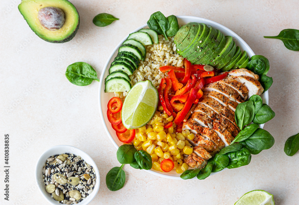 Bowl with bulgur, grilled chicken, bell pepper, cucumber, corn, avocado and spinach. Buddha bowl. Healthy food concept. Top view. Bowl with bulgur, grilled chicken, bell pepper, cucumber, corn, avocado and spinach. Buddha bowl. Healthy food concept. Top view.