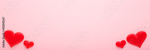 Bright red hearts on light pink table background. Pastel color. Closeup. Wide banner. Empty place for cute, emotional, sentimental text, romantic quote or sayings. Top down view.