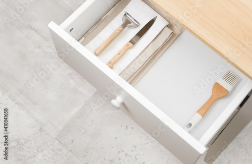 Photography Open kitchen drawer with towels, different cutlery and copy space