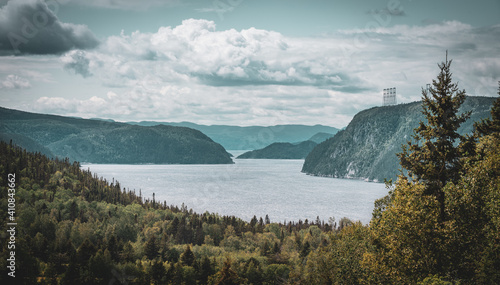 View point of fjord du Saguenay in Quebec Province on the East side with cloudy sky and windy weather. Green trees and grass on the foreground photo