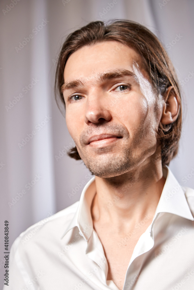 Fototapeta premium Portrait of handsome young man in a white shirt in studio against white background
