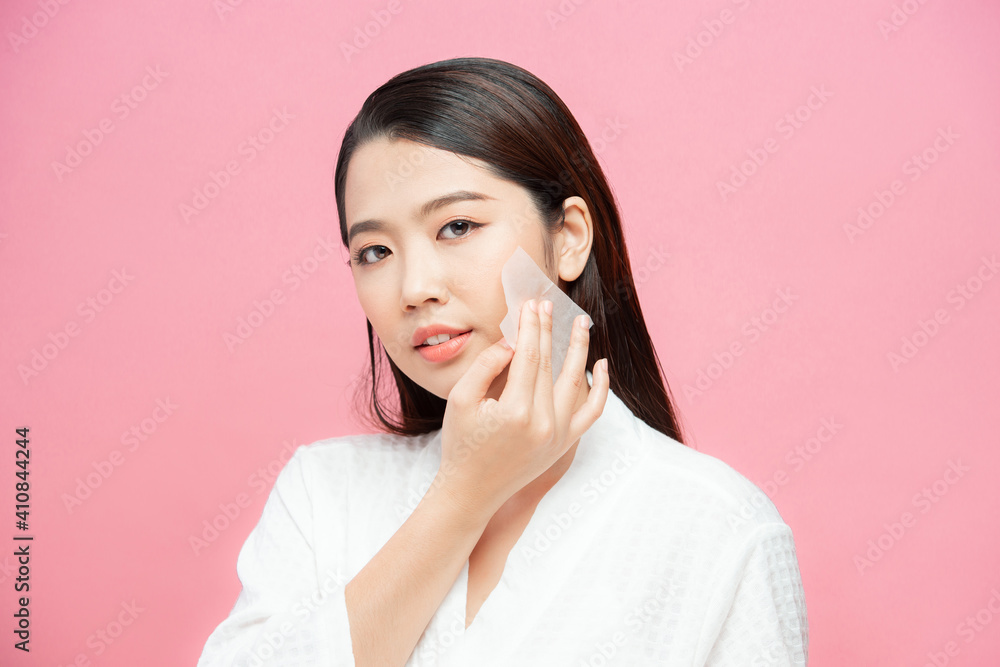 Face skin care. Smiling woman using facial oil blotting paper portrait. Face skin care. Smiling woman using facial oil blotting paper portrait.