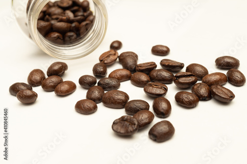 Coffee beans on white background and the bottle 