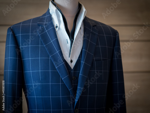 Close up of blue jacket blazer suit with black vest white shirt on mannequin detail photo