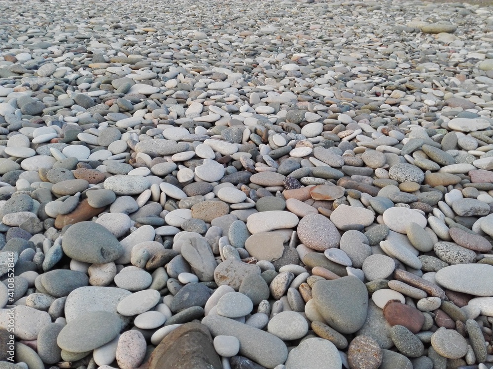 Perspective of rounded sea pebble stones & rock on beach natural abstract pebble texture background. Small multicolor river pebble rock stones. Close up colorful rock stones or gravel on ocean coast. Perspective of rounded sea pebble stones & rock on beach natural abstract pebble texture background. Small multicolor river pebble rock stones. Close up colorful rock stones or gravel on ocean coast.