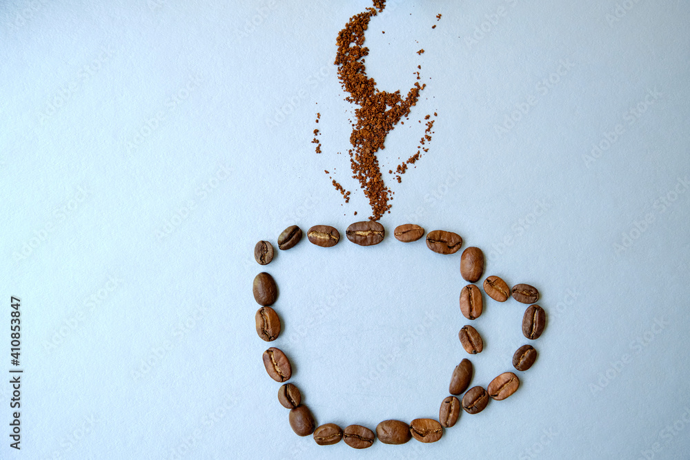 A cup of coffee made from coffee beans with smoke on it. Coffee consept. Cup on gray background. A cup of coffee made from coffee beans with smoke on it. Coffee consept. Cup on gray background.