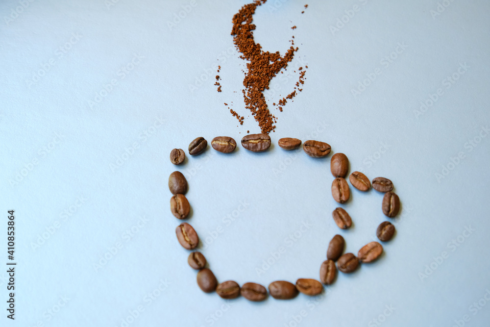 A cup of coffee made from coffee beans with smoke on it. Coffee consept. Cup on gray background. A cup of coffee made from coffee beans with smoke on it. Coffee consept. Cup on gray background.