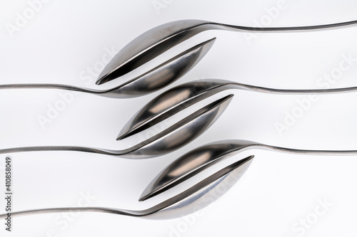 Artistic place setting photo of six spoons falling into each other.
