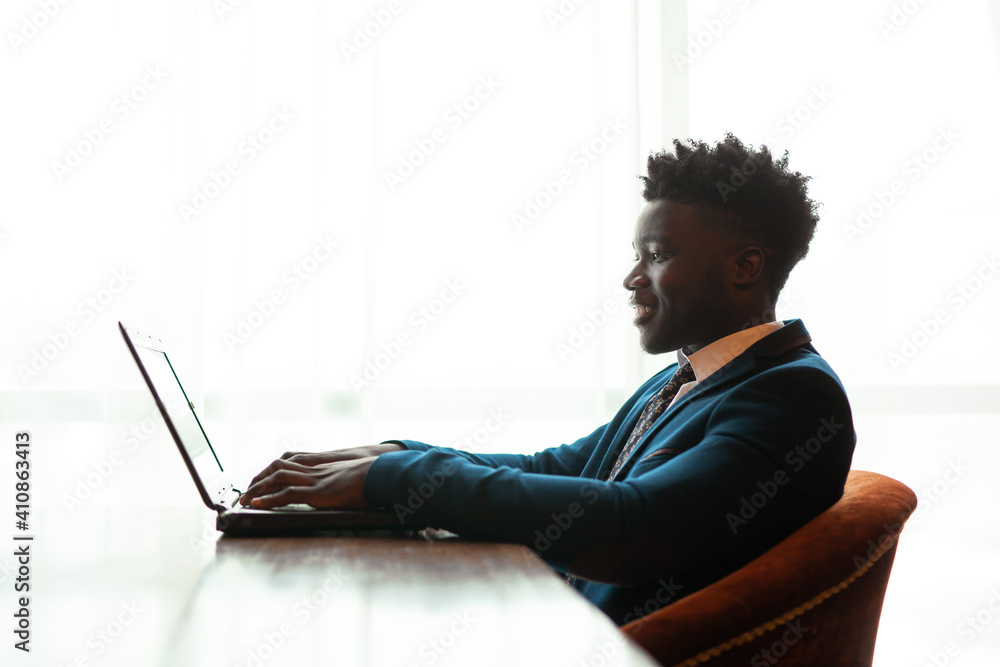 handsome young african man in suit indoors with laptop  - obrazy, fototapety, plakaty 