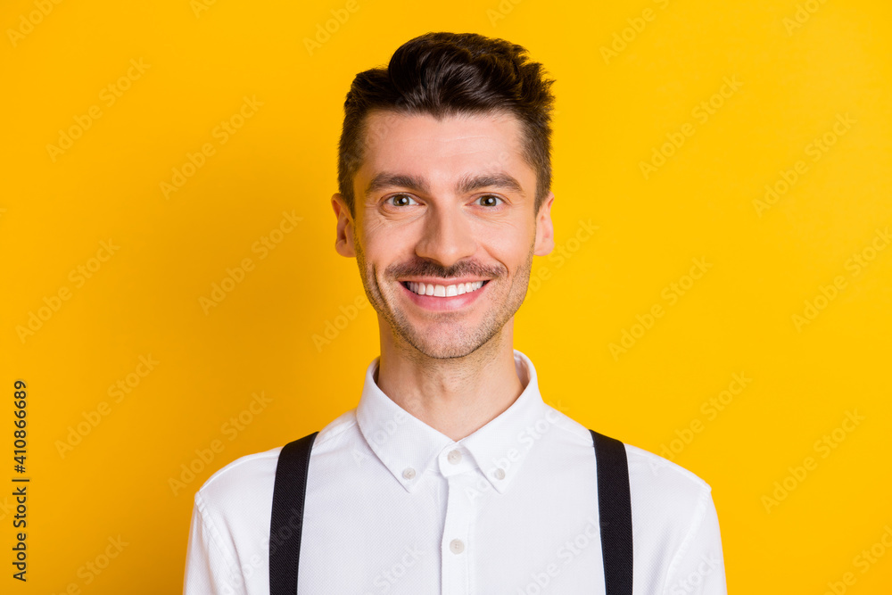 Close-up portrait of attractive content cheerful guy wearing white shirt isolated over bright yellow color background Close-up portrait of attractive content cheerful guy wearing white shirt isolated over bright yellow color background