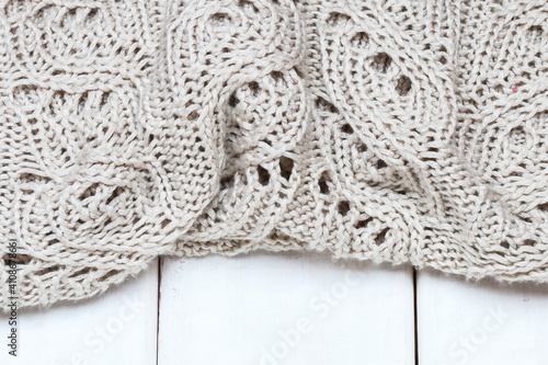 Knitted sweater lying on a wooden background.