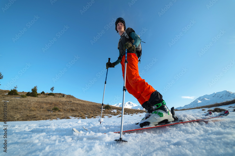Nice skiing in the snowy mountains at sunset. A young man athlete skier is standing in the mountains. Bottom view wide angle Nice skiing in the snowy mountains at sunset. A young man athlete skier is standing in the mountains. Bottom view wide angle