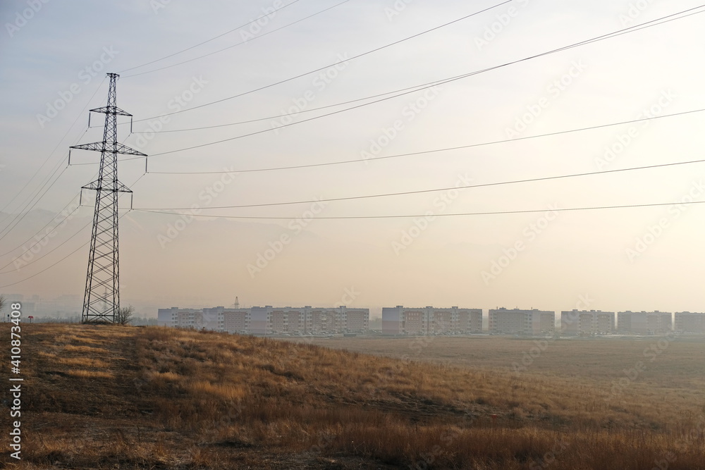 Almaty, Kazakhstan - 02.04.2021 : Power lines on the background of houses covered with a layer of smog Almaty, Kazakhstan - 02.04.2021 : Power lines on the background of houses covered with a layer of smog