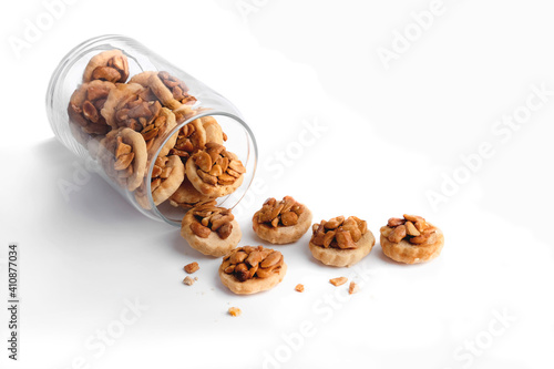 Homemade peanut butter cookies in a glass jar on white background.