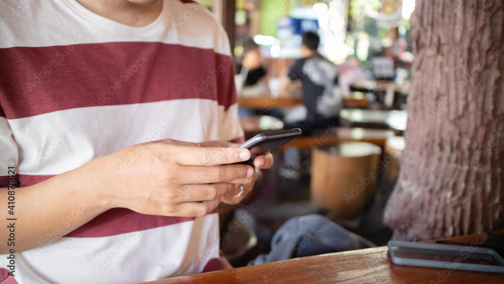 Hand using smartphone in restaurant. Hand using smartphone in restaurant.