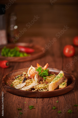 Vertical shot of deliciousspaghetti with shrimp on a wooden table photo