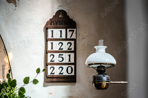 Foto Old dark oak wooden hymn board with four psalm numbers displayed on stone Church