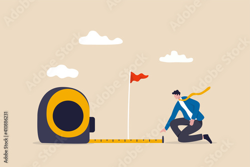 Business success measurement, how far from business goal and achievement or growth metric analysis concept, smart businessman using measuring tape to measure and analyze distance from target flag.