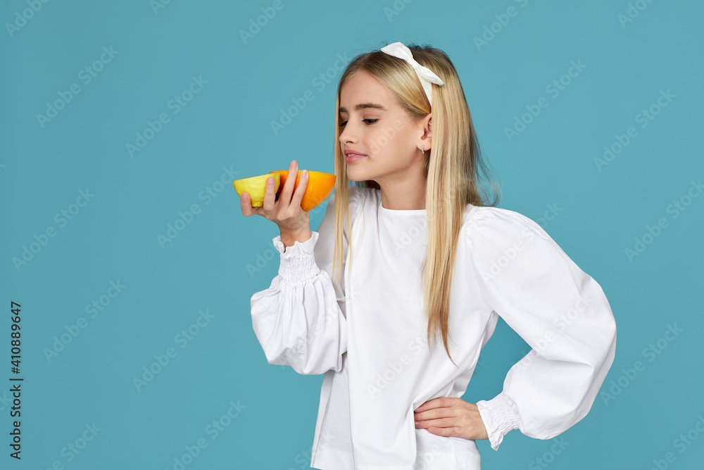 cute little child girl holding fresh juicy grapefruit isolated over blue background cute little child girl holding fresh juicy grapefruit isolated over blue background