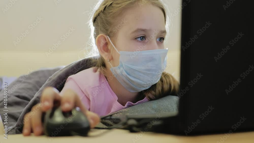 Cute girl wear protective masks and using laptop at home. Homeschooling, self-isolation, home quarantine. Technology, education, online learning, distance learning at home concept. Cute girl wear protective masks and using laptop at home. Homeschooling, self-isolation, home quarantine. Technology, education, online learning, distance learning at home concept.