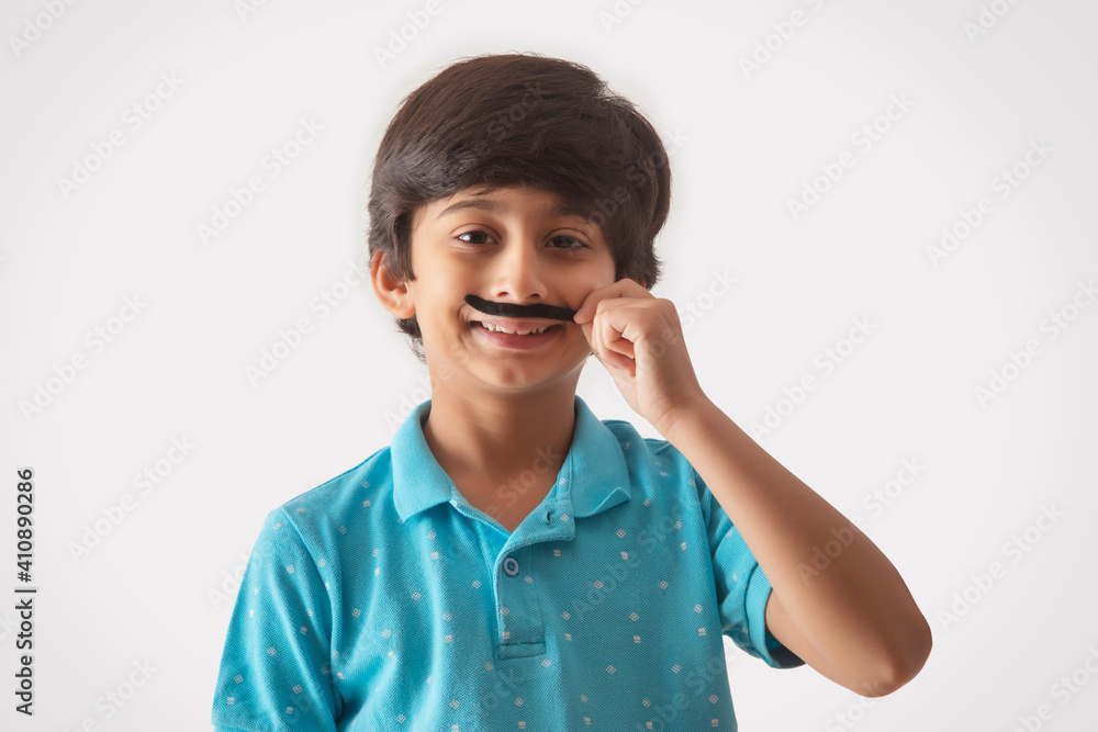 portrait of a young boy wearing artificial moustache portrait of a young boy wearing artificial moustache