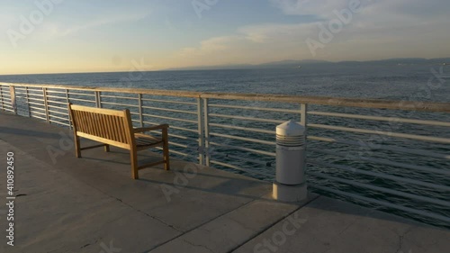 Hermosa Beach Pier famous La La Land scenary, enjoing beautiful view of ocean and empty bench photo