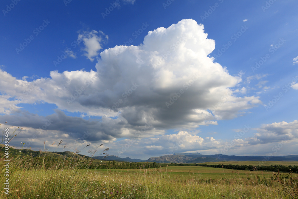 Beautiful summer landscape with white clouds in the blue sky over the valley and green meadows in Crimea Beautiful summer landscape with white clouds in the blue sky over the valley and green meadows in Crimea
