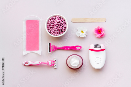 Set of epilation means - epilator with wax strips, razor and flowers. Top view