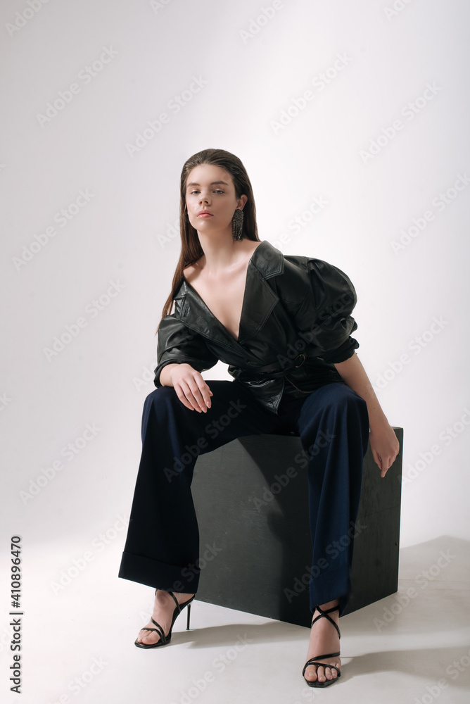 Young attractive girl model with dark long hair and a perfect figure with shining nude makeup posing in a trendy black leather jacket and chic long evening sparkling earrings. Beauty and fashion
Young attractive girl model with dark long hair and a perfect figure with shining nude makeup posing in a trendy black leather jacket and chic long evening sparkling earrings. Beauty and fashion