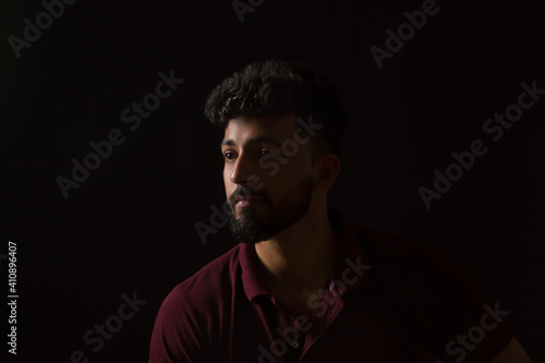 Portrait of a sad man sitting in the dark. 